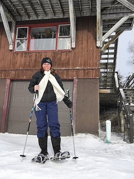 Snowshoer in front of building at cross-country ski center in Lake Placid.