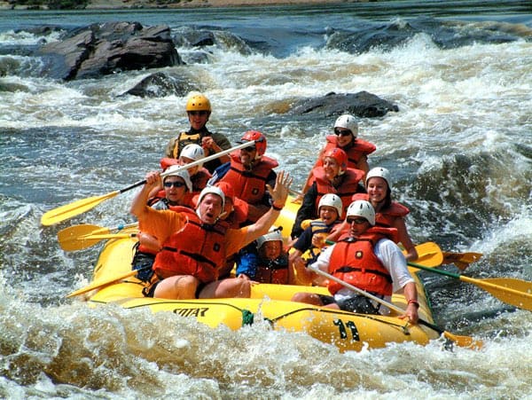 people paddling a yellow raft in whitewater