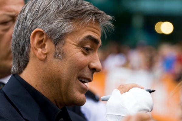 george clooney signing an autograph at tiff, as he often does at film festivals.