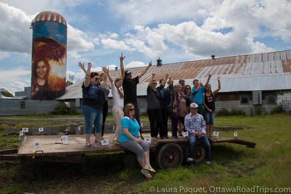 the popsilos partners celebrate the launch in the shadow of a silo painted by lacey jane and layla folkmann at the farm of michel dignard and jeannette mongeon in embrun.