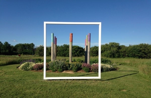 White frame surrounding sculpture in garden. Bee Haven by Engelina Schmitz with Canada Council Art Bank sculpture. Photo courtesy of Beyond the Edge: Artists' Gardens.