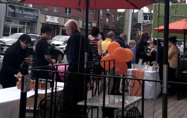 People sampling food at booths along Wellington Street during Tastes of Wellington West.