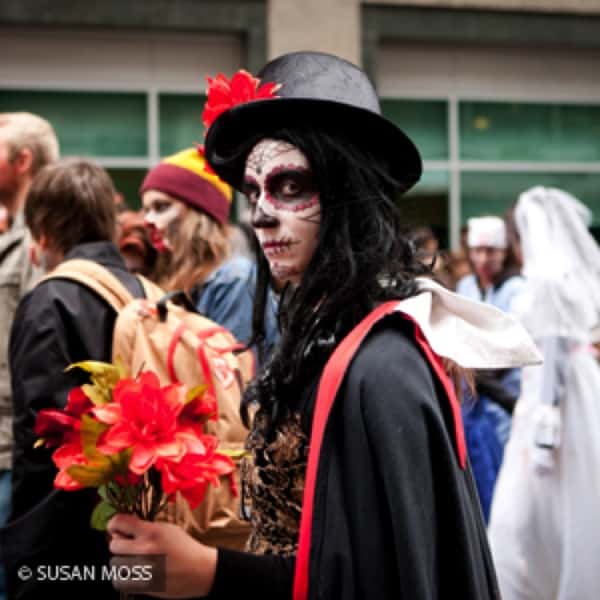 zombie holding flowers and looking sullenly at camera.