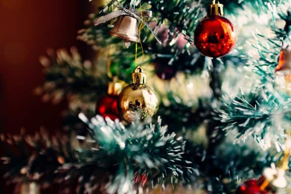 Close-up of red and gold round ornaments on a decorated Christmas tree.