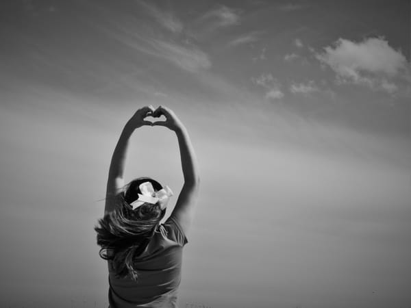 Black and white photo of woman stretching her hands over her head.