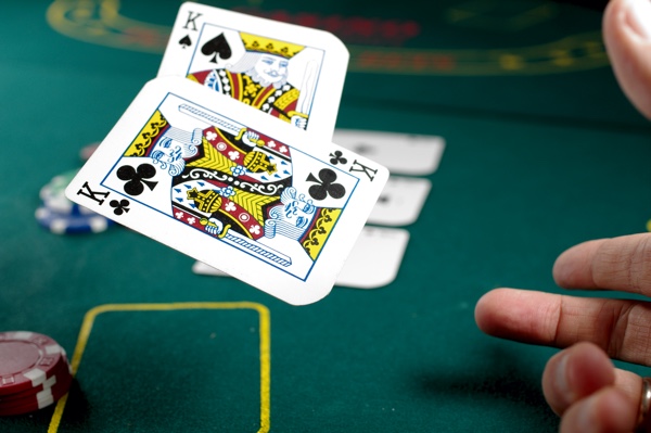 Two playing cards (kings) being tossed on a gaming table in a casino. https://unsplash.com/photos/oT-XbATcoTQ