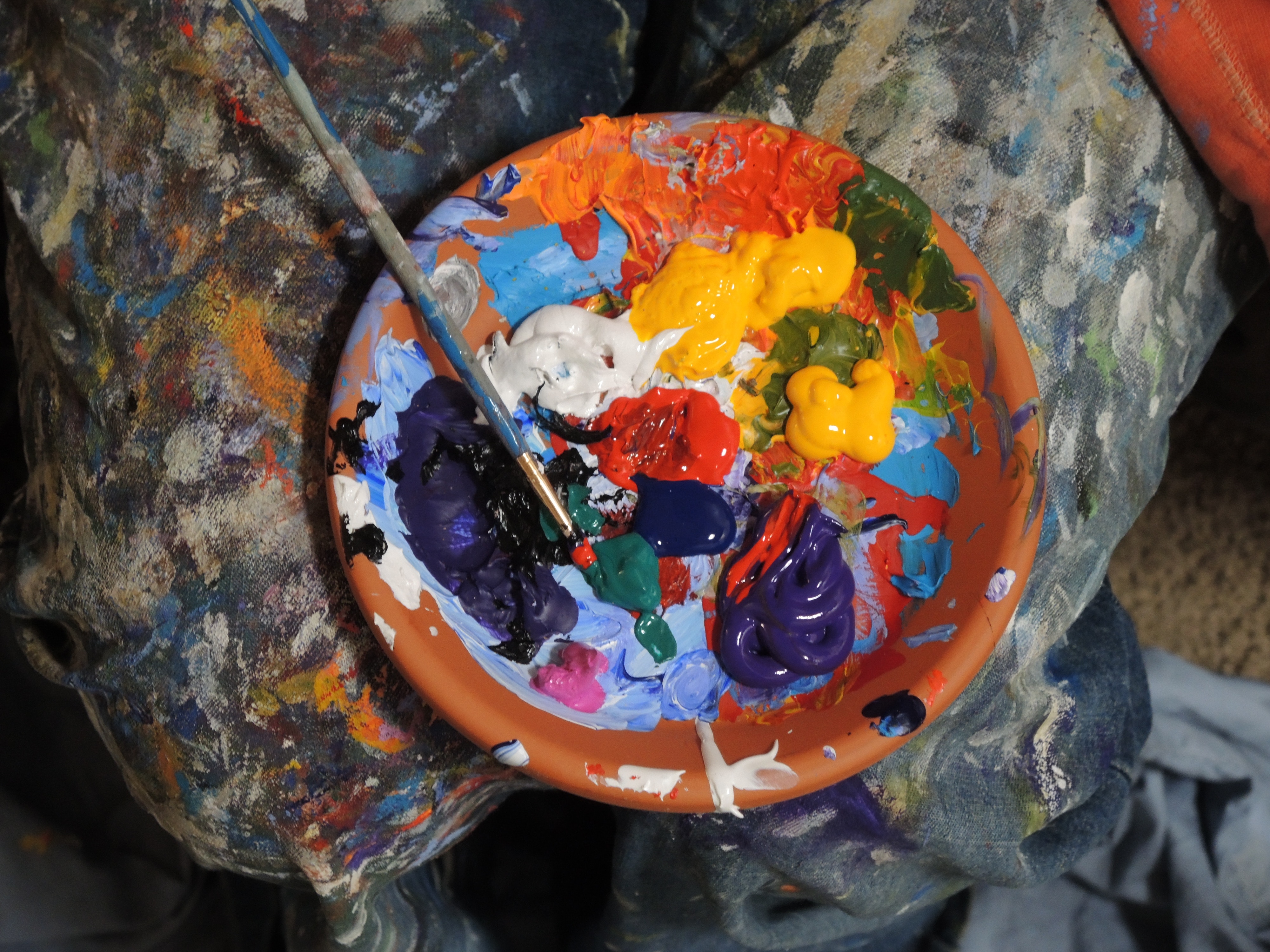 Paintbrush and paints in a clay palette. Photo by Mike Petrucci on Unsplash.