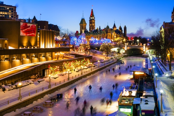 rideau canal at twilight with skaters and christmas lights across canada.