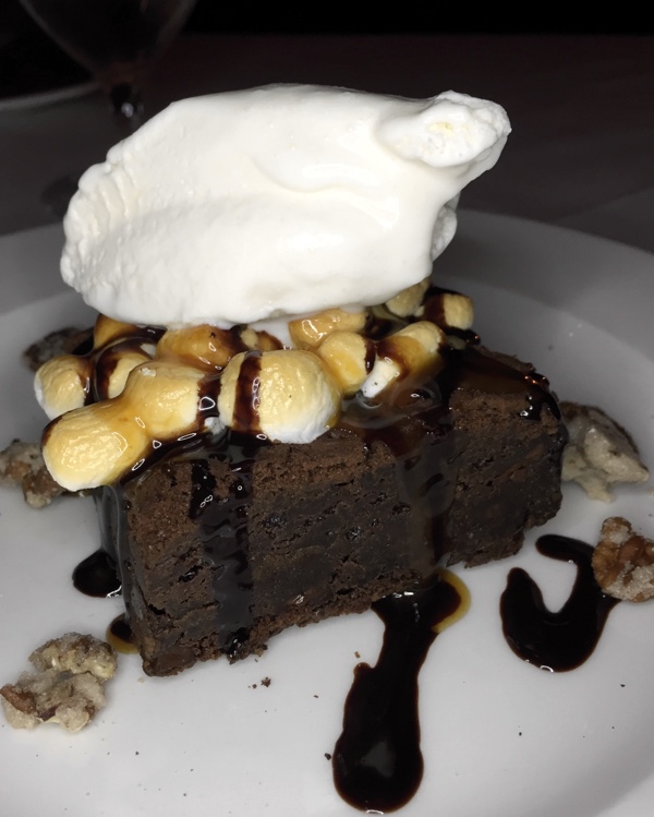 brownie topped with ice cream, caramelized marshmallows and chocolate sauce.