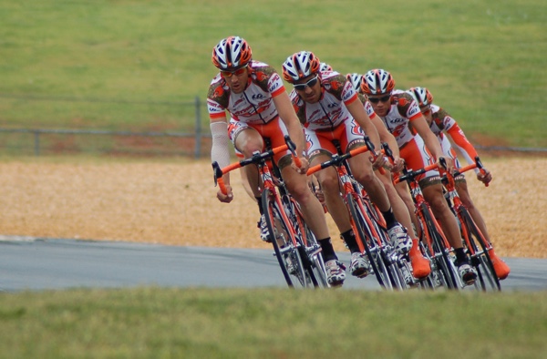 Competitive cyclists racing around a turn. Photo by James Thomas on Unsplash.