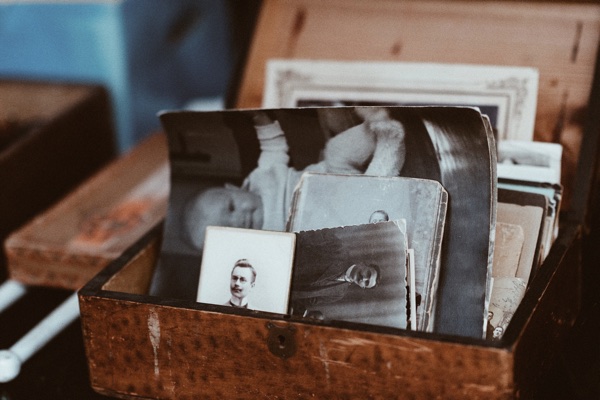 Old photos in a box. Photo by Roman Kraft on Unsplash.