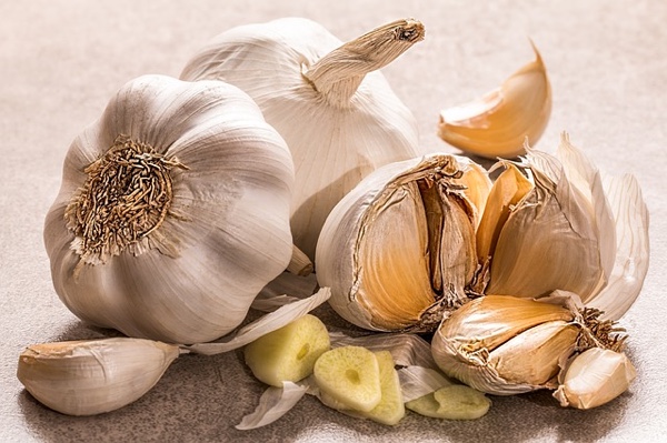 Raw garlic cloves, whole and partly split.