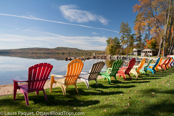 Muskoka chairs overlook Calabogie Lake and Ottawa Valley fall colours at Jocko's Beach Resort and Motel.