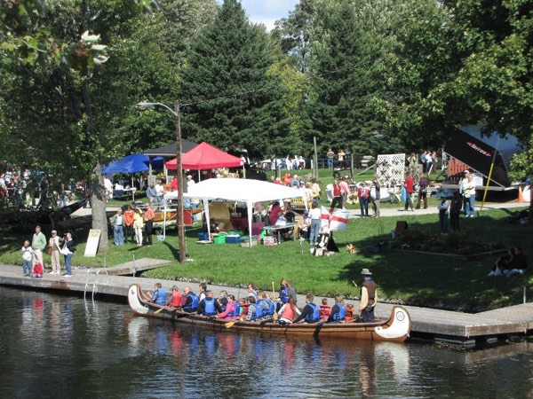 Voyageur canoe in the water beside the fairgrounds at the Lyndhurst Turkey Fair.