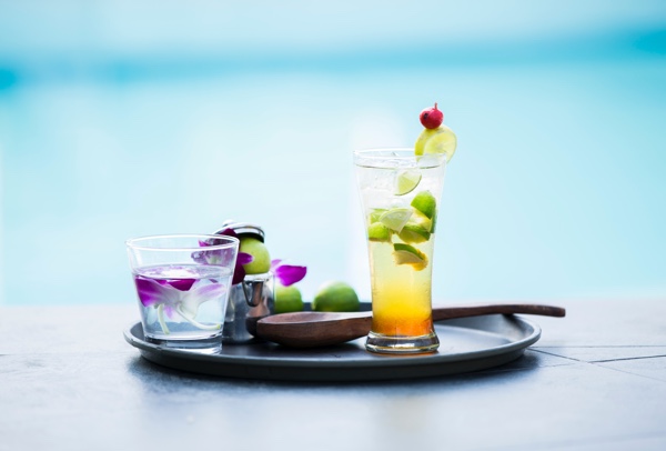 Cocktails and fruit against a light blue background.