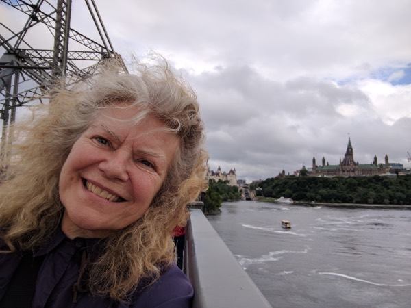 Katharine exploring the capital. On the Alexandria Bridge with Château Laurier rear left; Entrance Bay Locks to the Rideau Canal, and Parliament Hill, rear right. Photo by Katharine Fletcher.