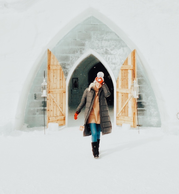 hollie at the wooden doors at the entrance to the hôtel de glace in valcartier, near quebec city.