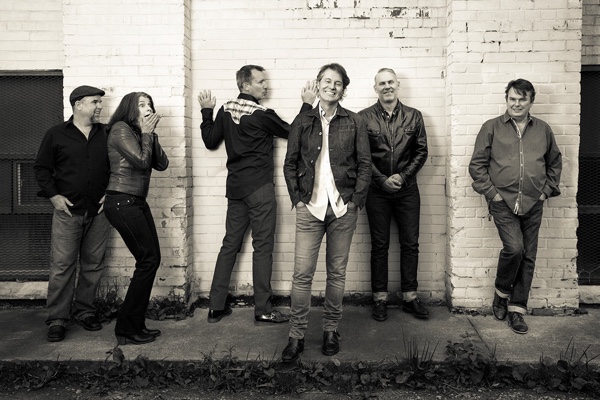 Jim Cuddy Band posing against a wall. Black and white photo.