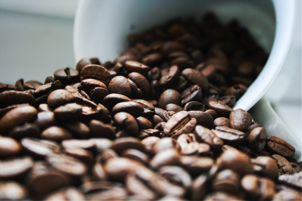 coffee beans spilling out of a white container