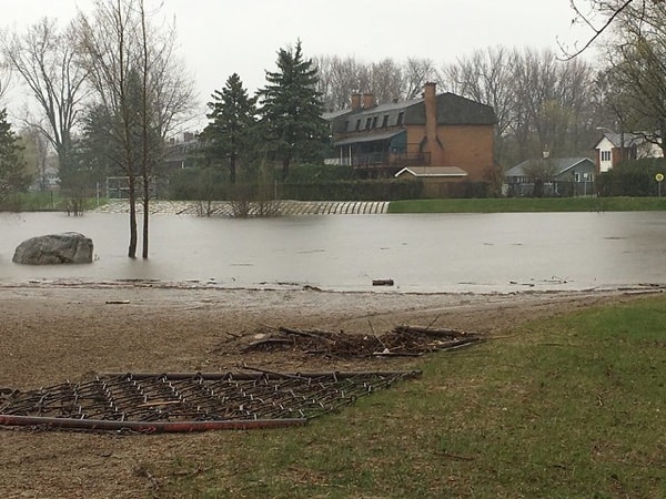 Water and park in foreground with houses in background.