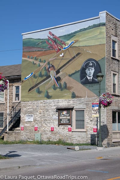 a colourful mural on the side of a stone building in carleton place showing an aerial battle between captain roy brown and the red baron.