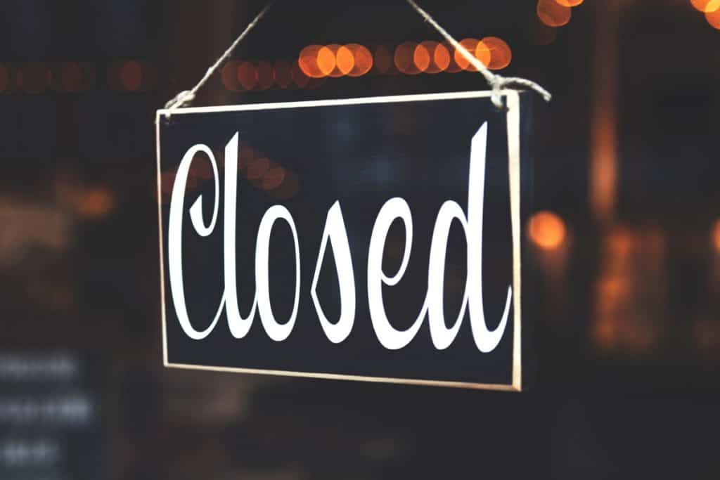 black and white sign reading "closed", hanging in a window