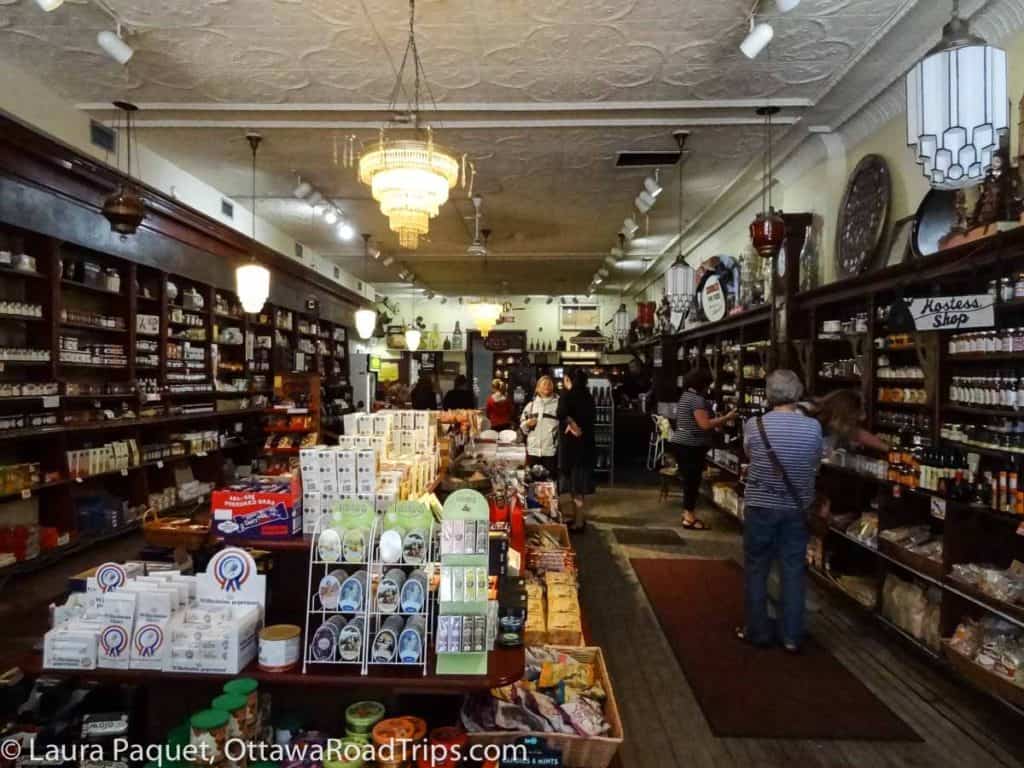 store interior with long rows of dark wood shelves filled with food jars and packages
