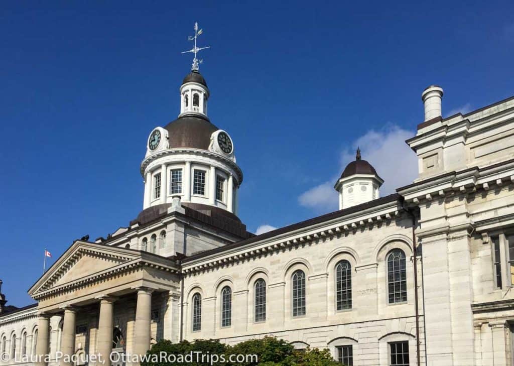 kingston city hall is a large limestone building with columns at front and large dome with cupola