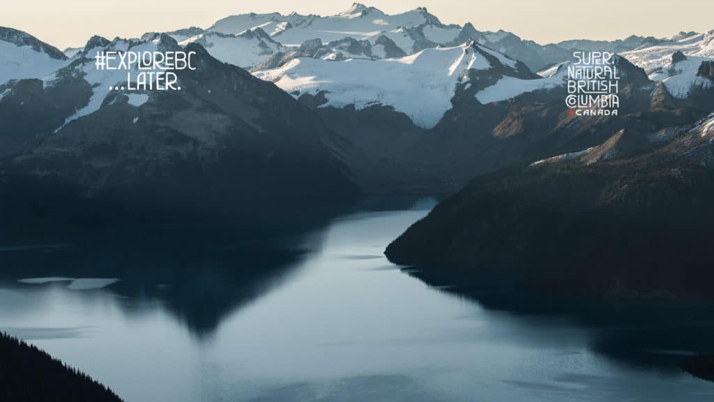 Zoom background of snow-capped mountains in British Columbia, with waterway in the foreground.