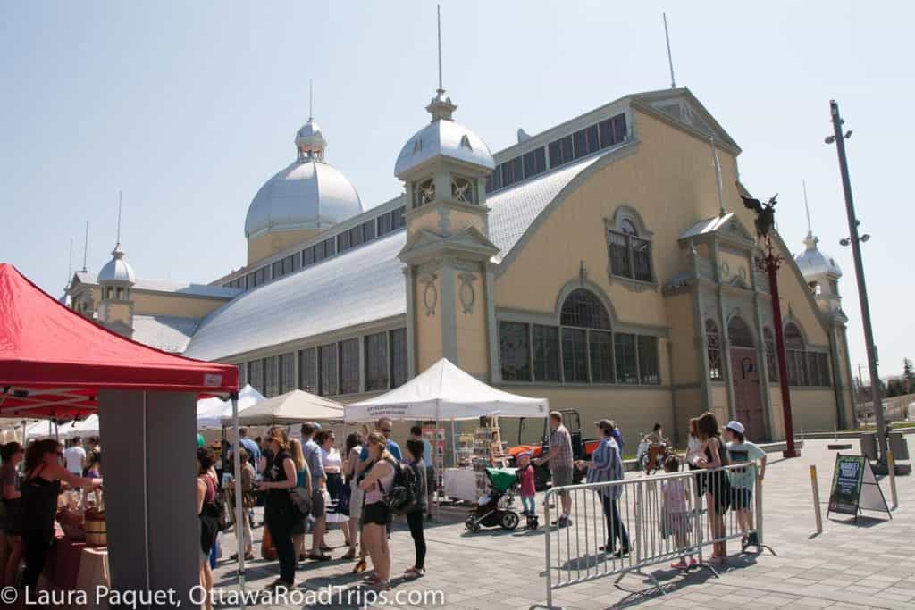 farmers market in front of large yellow market building (aberdeen pavilion) at lansdowne park.