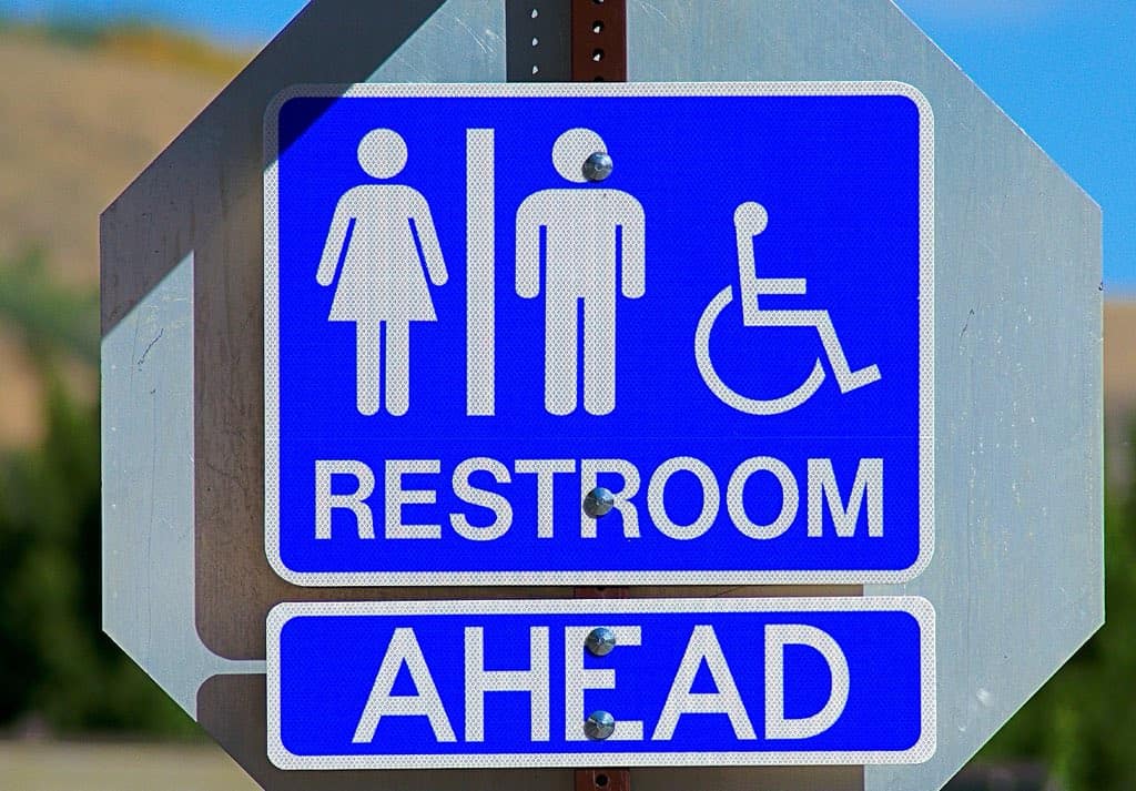 blue and white washroom sign with female, male and disability logos.