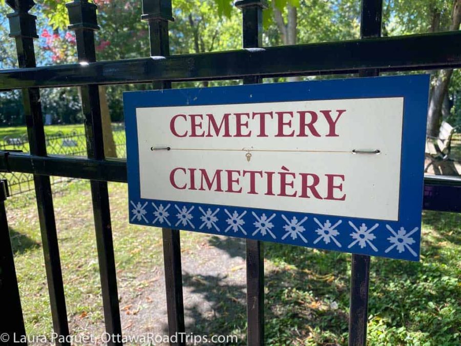 red white and blue sign reading "cemetery" on wrought-iron fence