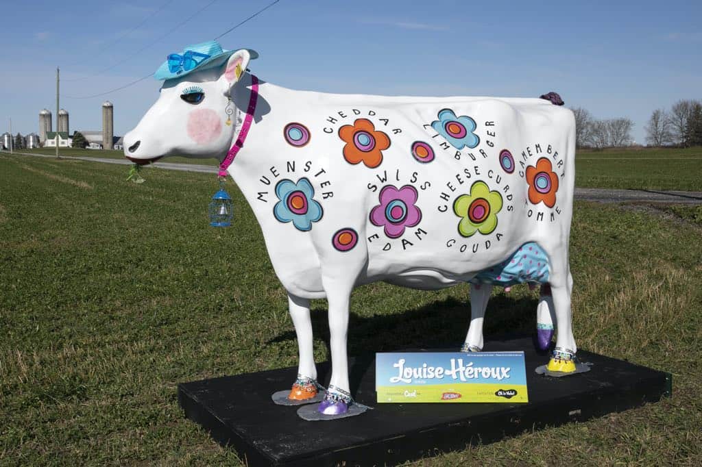white cow statue painted with multicoloured flowers for festival de la curd