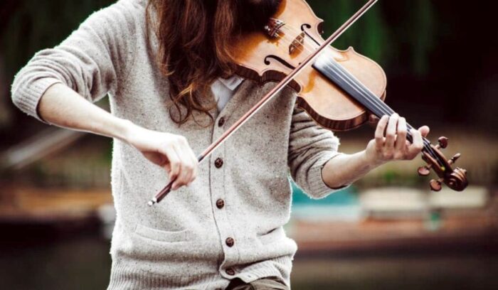 clem-onojeghuo-fiddler-unsplash - Ottawa Road Trips closeup of a woman fiddling