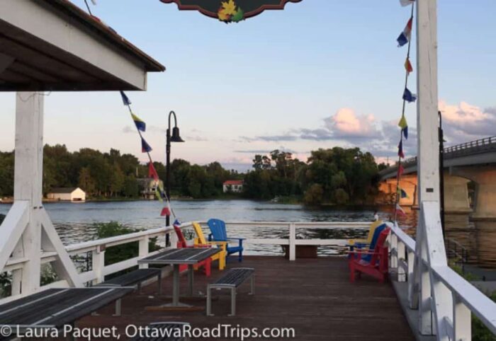 dock with muskoka chairs beside a river