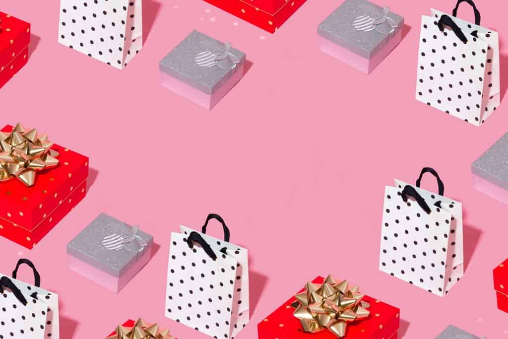 Red, white and pink graphic of shopping bags and wrapped gifts