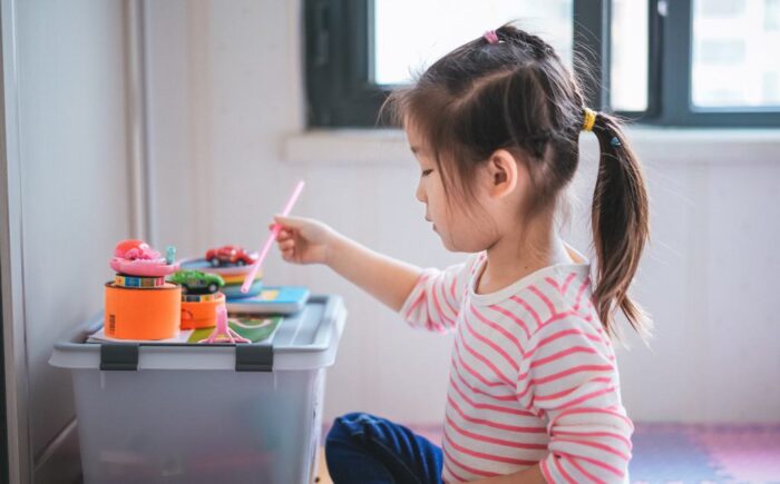 young child sitting at a low table painting