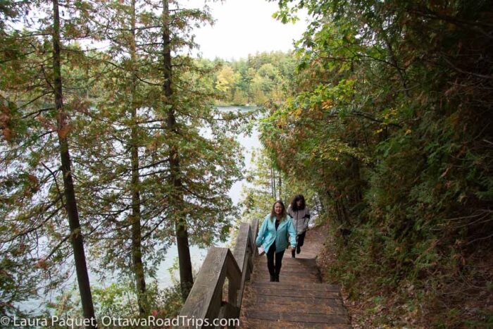 pink-lake-stairs - Ottawa Road Trips hikers walking down wooden stairs to a small lake