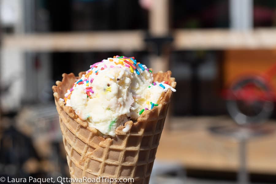 closeup of vanilla ice cream with sprinkles in a waffle cone