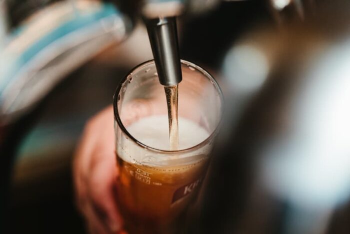 closeup of beer coming out of a tap into a large glass