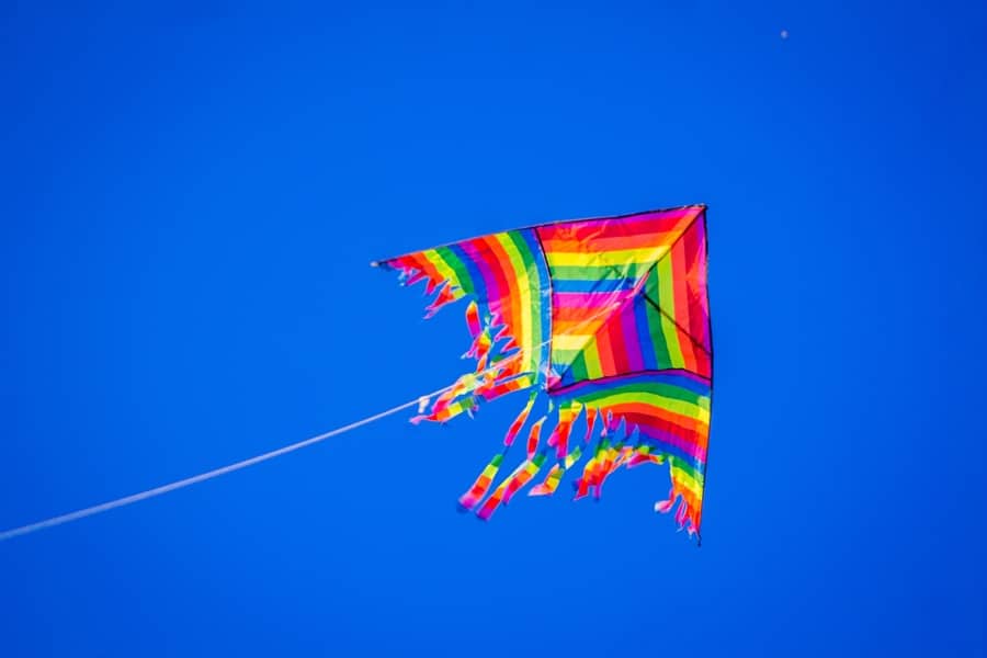 multicoloured striped kite against a blue sky