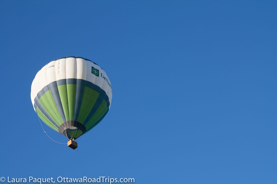 green and white hot air balloon in a blue sky