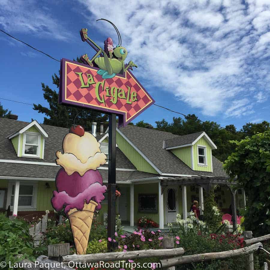 ice cream cone sign in foreground with yellow house in background