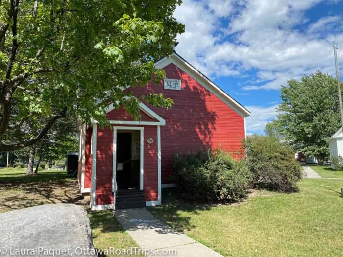 lost-villages-museum-schoolhouse - Ottawa Road Trips small red wooden schoolhouse on a green lawn