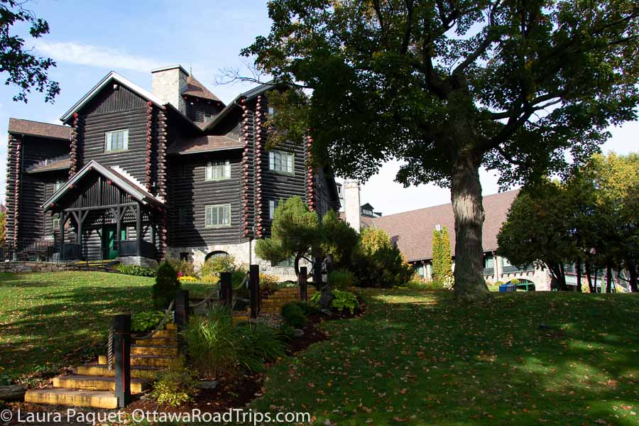 large log building at the top of a small hill, shaded by trees. fairmont montebello.