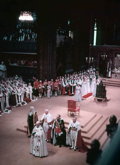 coronation ceremony photographed from above, with Queen Elizabeth in a long white dress