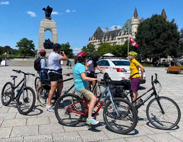 cyclists stopped and taking pictures in confederation square in ottawa