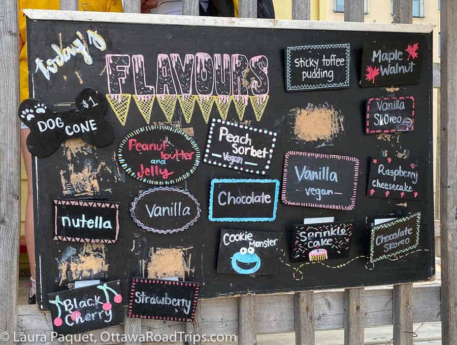 a blackboard with colourful signs showing different ice cream flavours.