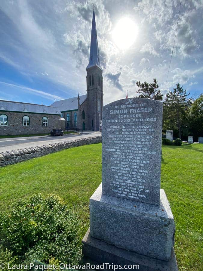 Simon Fraser gravestone with large church in background in St. Andrews West, Ontario.