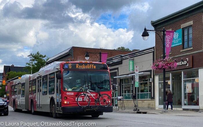 red and white 6 rockcliffe oc transpo bus in front of small stores in Glebe